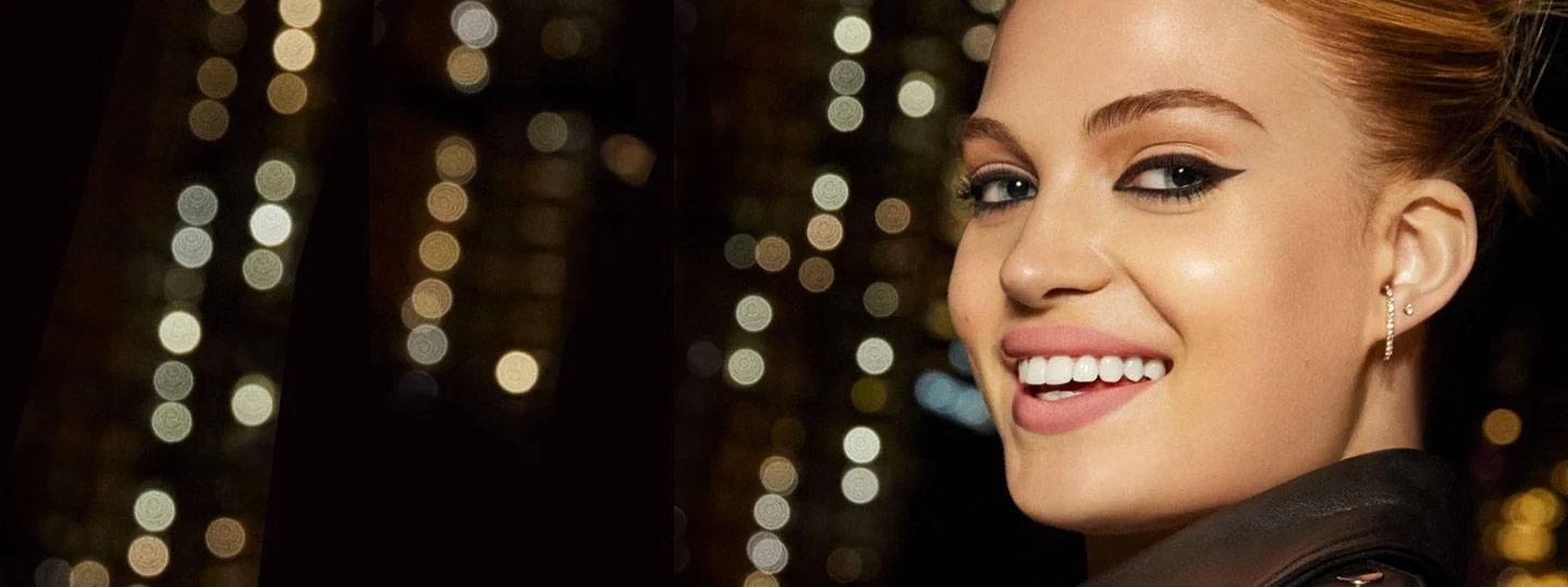 หญิงสาวยิ้ม - พื้นหลังคือแสงไฟในเมือง